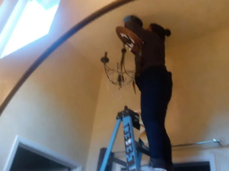 Electrician installing a chandelier in a Hollymead residence